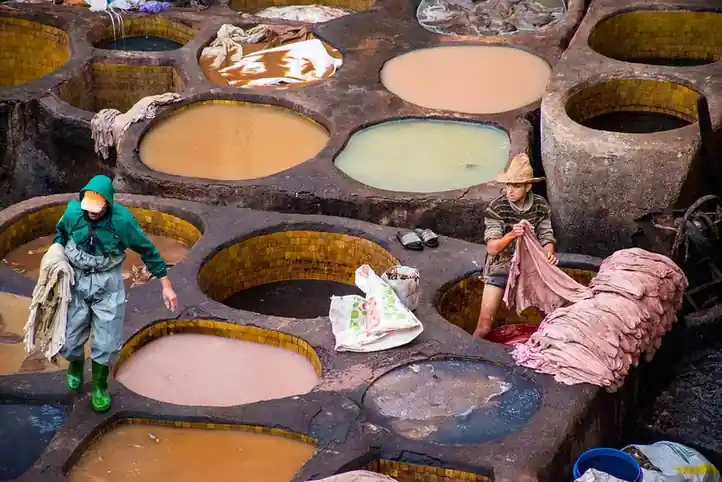 Piletas redondas de una curtiembre tradicional vistas desde arriba, con cueros tendidos entre ellas